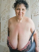 Curly brunette mature demonstrates her enormous boobs