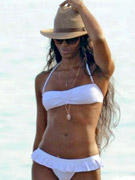 Black panther naomi campbell rocking on the beach in a white bikini and a hat